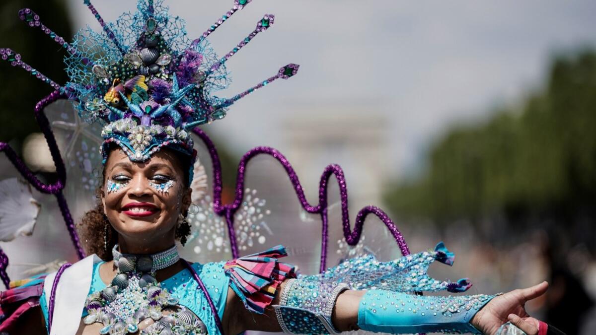 People parade during the Tropical Carnival on July, 7 2019 in Paris.  Kenzo TRIBOUILLARD / AFP
