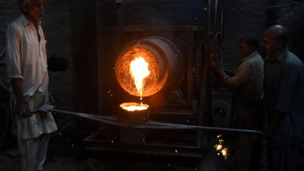 Pakistani labourers pour melted metal into a cast at an iron factory in Karachi on April 30, 2019, on the eve of the International Labour Day celebrated on May 1.  ASIF HASSAN / AFP