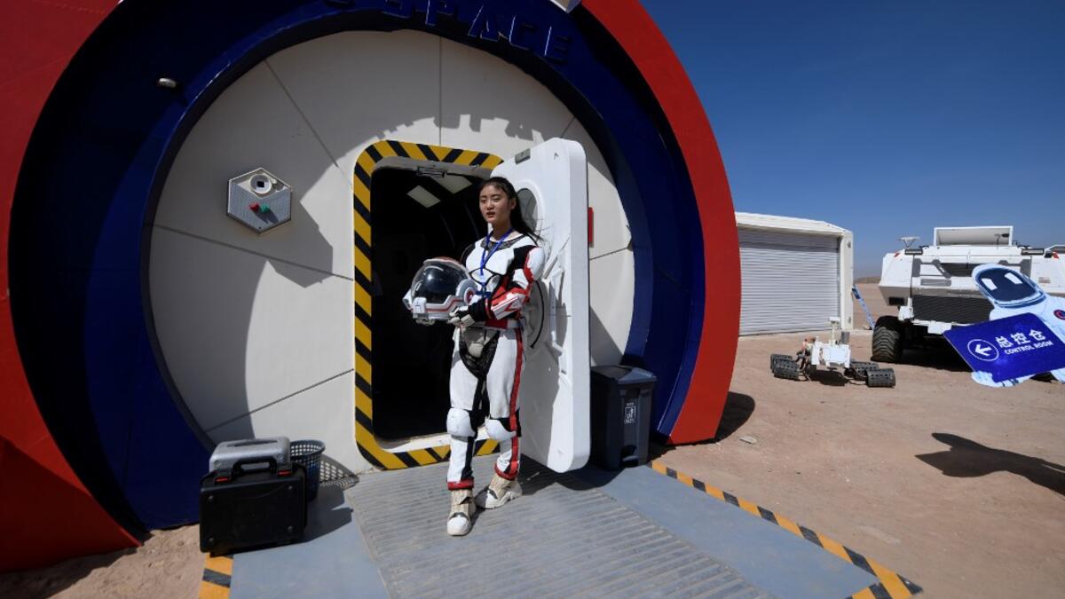 A guide wearing a space suit stands at an entrance at "Mars Base 1", a C-Space Project, in the Gobi desert, some 40 kilometres from Jinchang in China's northwest Gansu province on April 17, 2019. WANG ZHAO / AFP