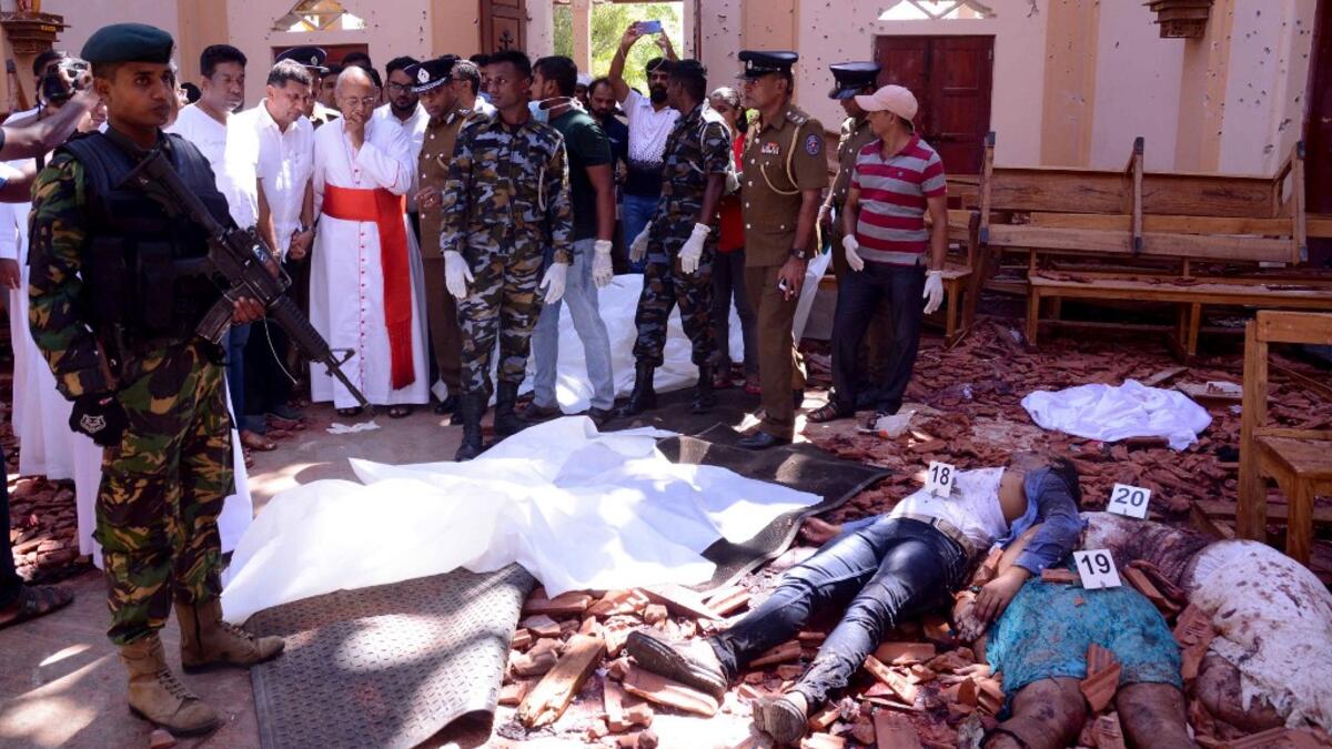 Sri Lanka soldiers and religious members of the parish look on inside the St Sebastian's Church at Katuwapitiya in Negombo on April 21, 2019, following a bomb blast during the Easter service that killed tens of people. STR / AFP