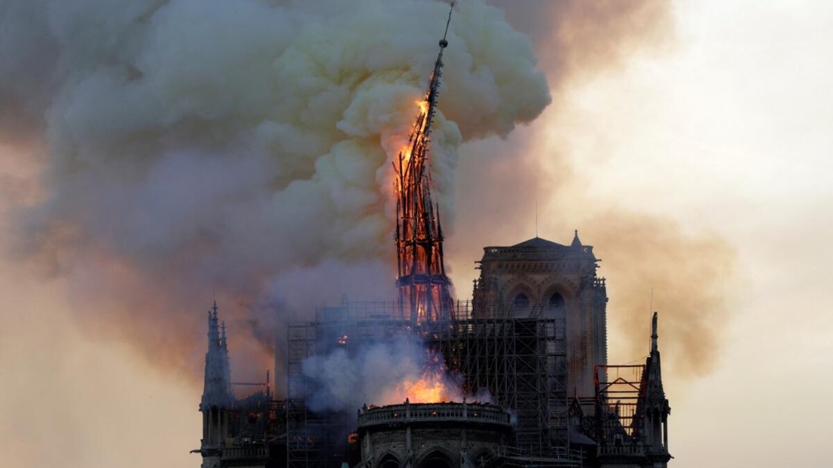 The steeple of the landmark the Notre-Dame Cathedral collapses as it is engulfed in flames in central Paris on April 15, 2019. Geoffroy VAN DER HASSELT / AFP