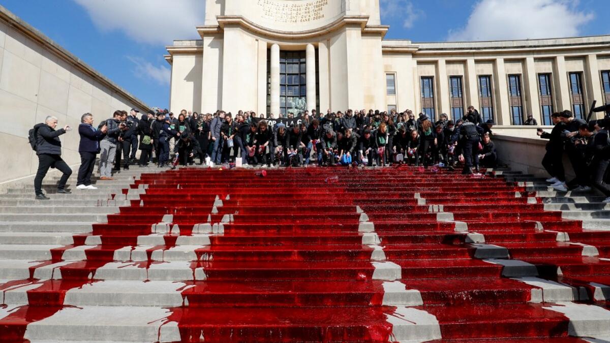 Members of the action group Extinction Rebellion (XR) spill fake blood on the steps of the Trocadero esplanade during a demonstration to alert on the state of decline of biodiversity, on May 12, 2019 in Paris. FRANCOIS GUILLOT / AFP