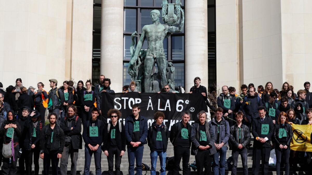 Members of the action group Extinction Rebellion (XR) hold a banner after spilling fake blood on the steps of the Trocadero esplanade during a demonstration to alert on the state of decline of biodiversity, on May 12, 2019 in Paris. FRANCOIS GUILLOT / AFP