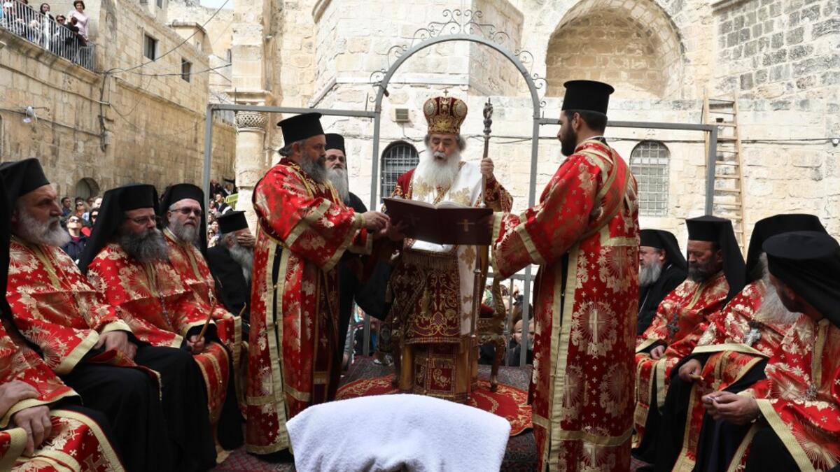 Greek Orthodox Patriarch of Jerusalem, Theophilos III (C), leads the traditional Washing of the Feet ceremony in front of the church of the Holy Sepulchre in Jerusalem's Old City, on April 25, 2019, as part of the Orthodox Holy Week celebrations.  GALI TIBBON / AFP