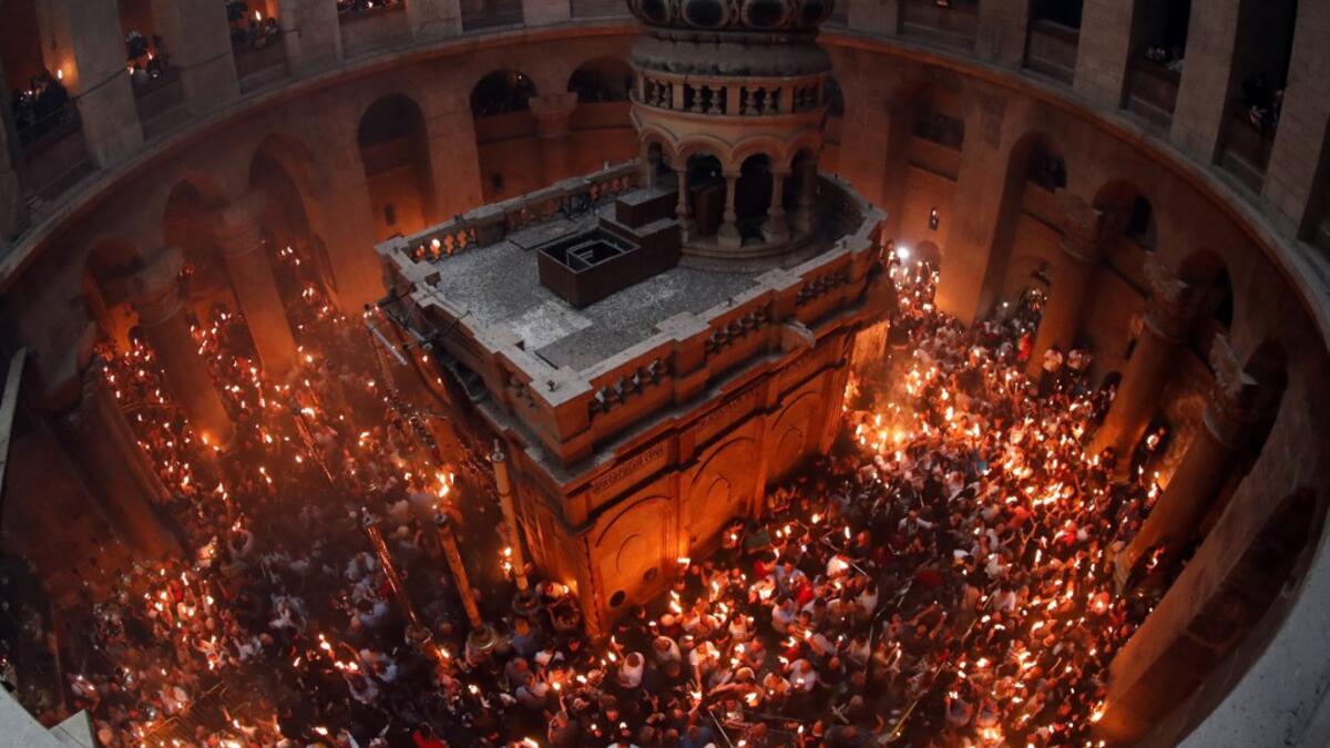 Christian Orthodox worshippers hold up candles lit from the ‘Holy Fire’ as they gather in the Church of the Holy Sepulchre in Jerusalem’s Old City on April 27, 2019. THOMAS COEX / AFP