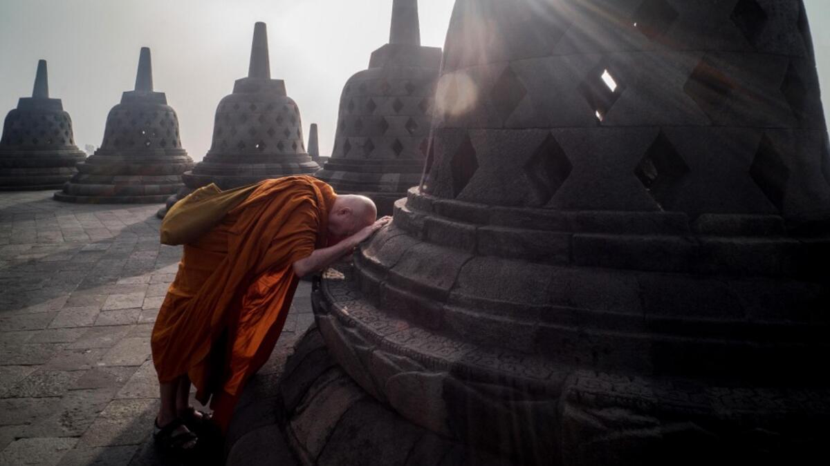 Buddhist monk prays on the eve of Buddha's birthday also known as Vesak celebrations, at Borobudur temple in Magelang, Central Java province, on May 18, 2019. Buddhists are celebrating Vesak, which commemorates the birth of Buddha, his attaining enlightenment and his passing away on the full moon day of May which falls on May 18 this year. OKA HAMIED / AFP