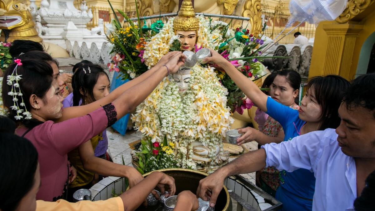 Buddhist devotees pour water at Shwedagone pagoda during Buddha's birthday which falls on the Full Moon Day of Kasone in Yangon, on May 18, 2019.  Sai Aung MAIN / AFP